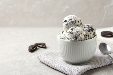 Photo of Bowl with ice cream and crumbled chocolate cookies on table, space for text