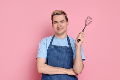 Photo of Portrait of happy confectioner holding whisk on pink background