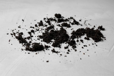 Photo of Scattered coffee grounds on light surface, closeup