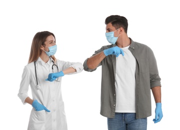 Photo of Doctor and patient doing elbow bump instead of handshake on white background. New greeting during COVID-19 pandemic