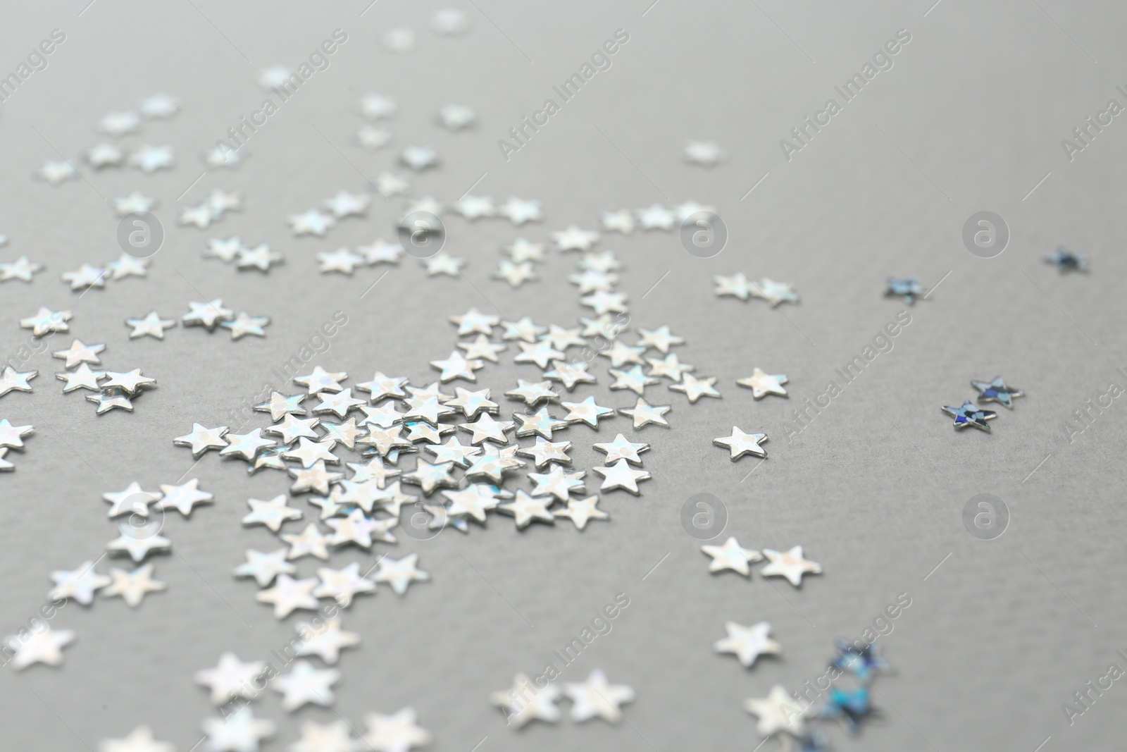 Photo of Confetti stars on grey background, closeup. Christmas celebration