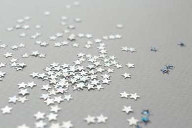 Photo of Confetti stars on grey background, closeup. Christmas celebration