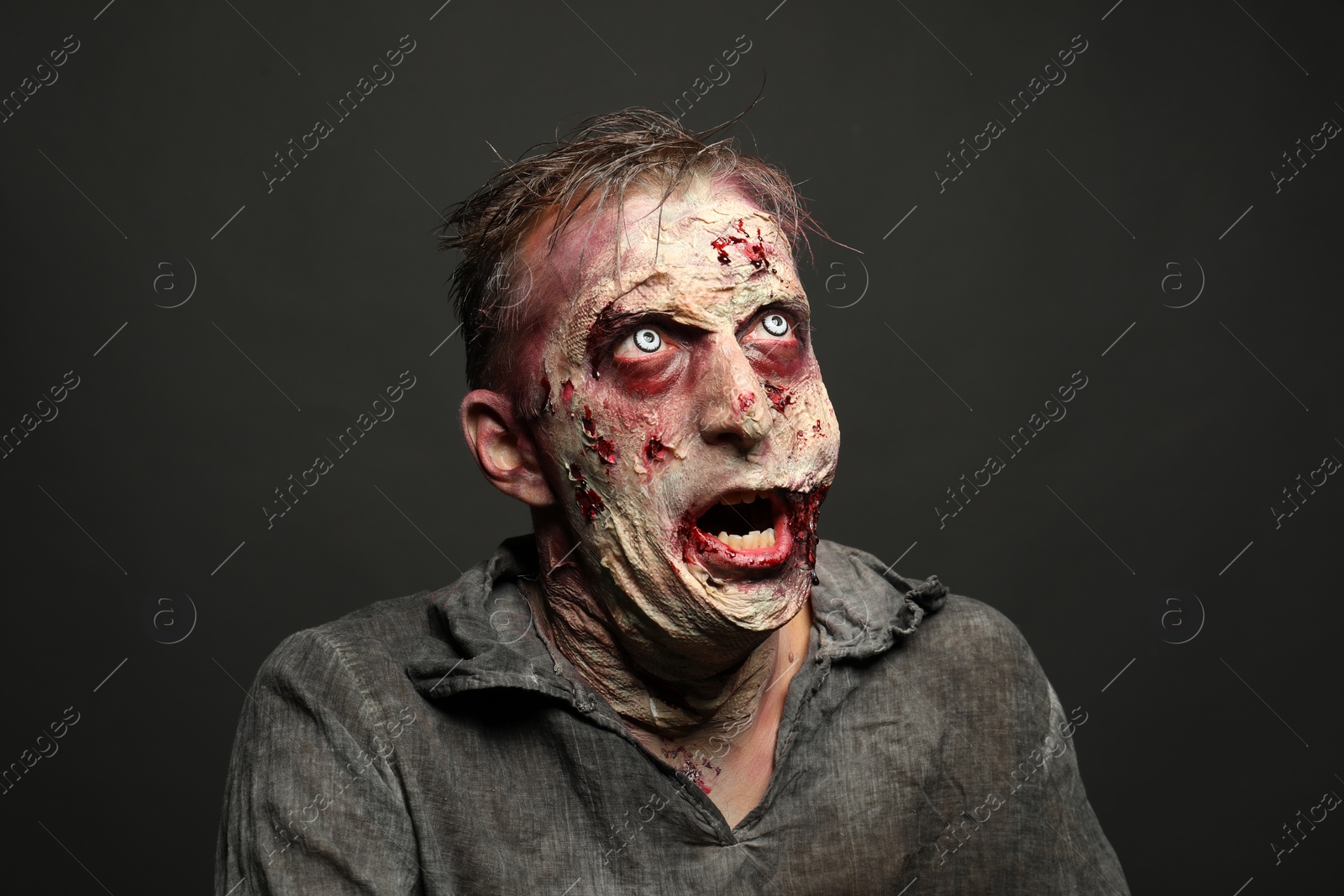 Photo of Scary zombie on dark background. Halloween monster