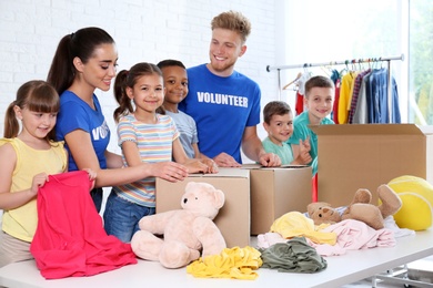 Volunteers with children sorting donation goods indoors