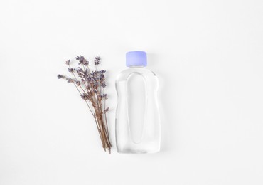 Photo of Transparent bottle with baby oil and dried lavender on white background, flat lay