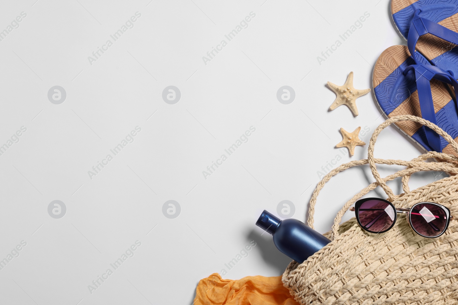 Photo of Flat lay composition with wicker bag and other beach accessories on white background. Space for text