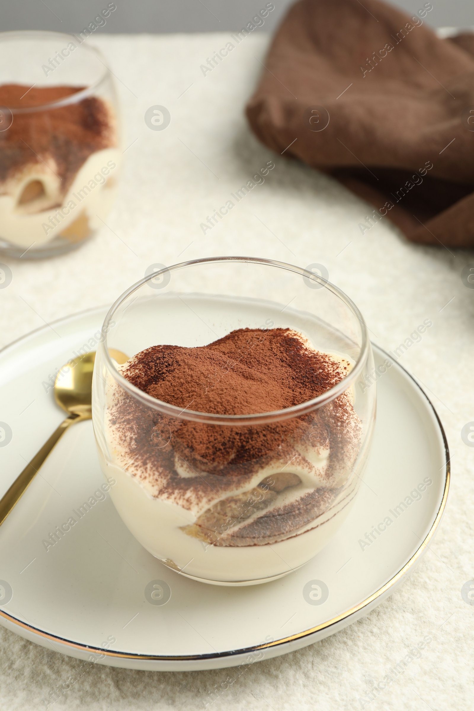 Photo of Delicious tiramisu in glasses on white table