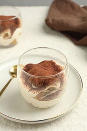 Delicious tiramisu in glasses on white table