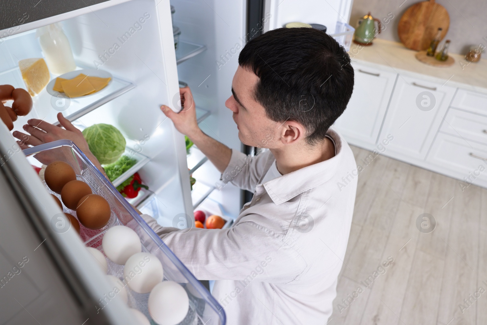 Photo of Man near refrigerator in kitchen at home, above view