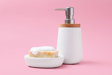 Soap bar and bottle dispenser on pink background