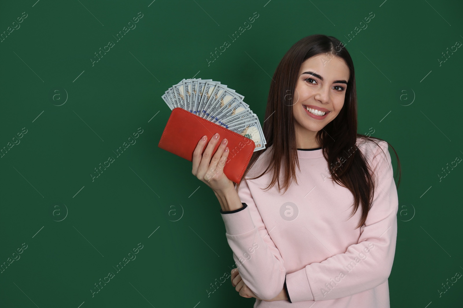 Photo of Young woman with money in wallet on color background. Space for text