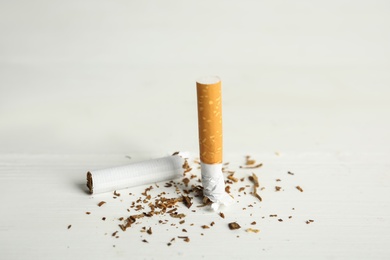 Broken cigarette on white table. Quitting smoking concept