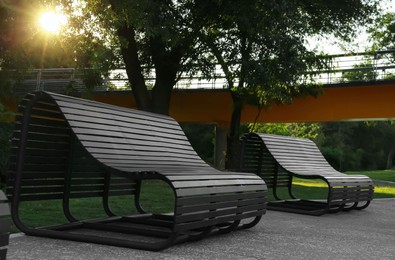 Photo of Beautiful wooden benches in park near trees