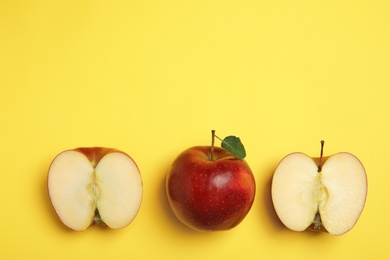 Flat lay composition with ripe juicy red apples on yellow background, space for text