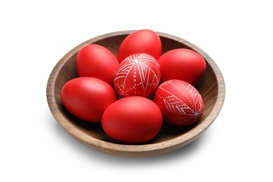 Wooden bowl with painted red Easter eggs on white background