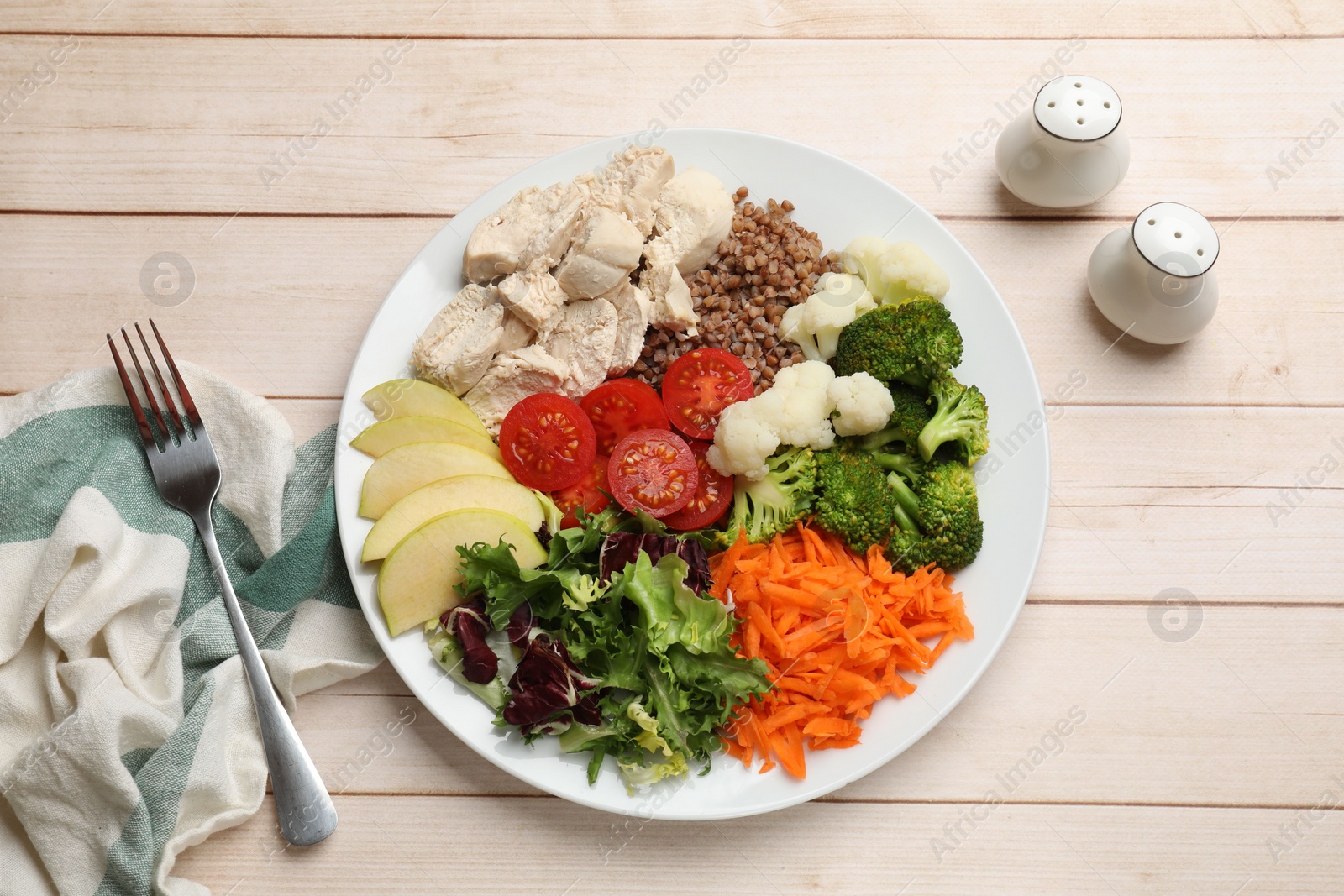 Photo of Balanced diet and healthy foods. Plate with different delicious products served on light wooden table, top view