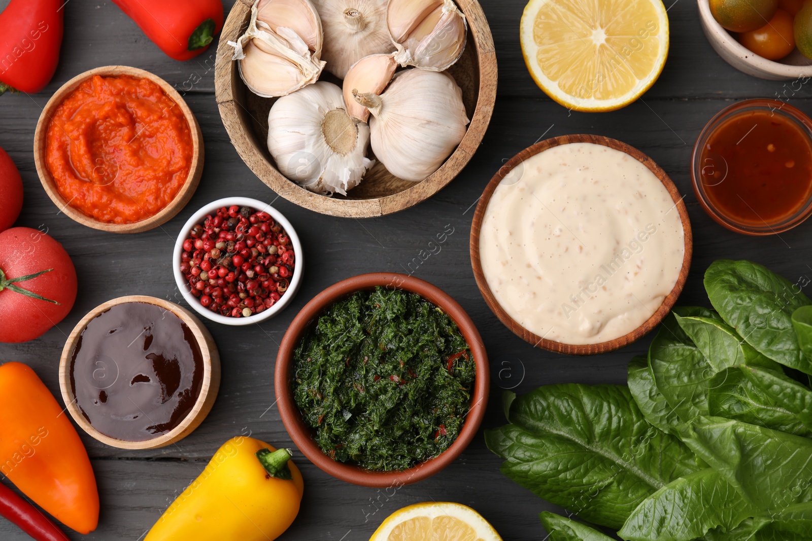 Photo of Different fresh marinades in bowls and ingredients on grey wooden table, flat lay