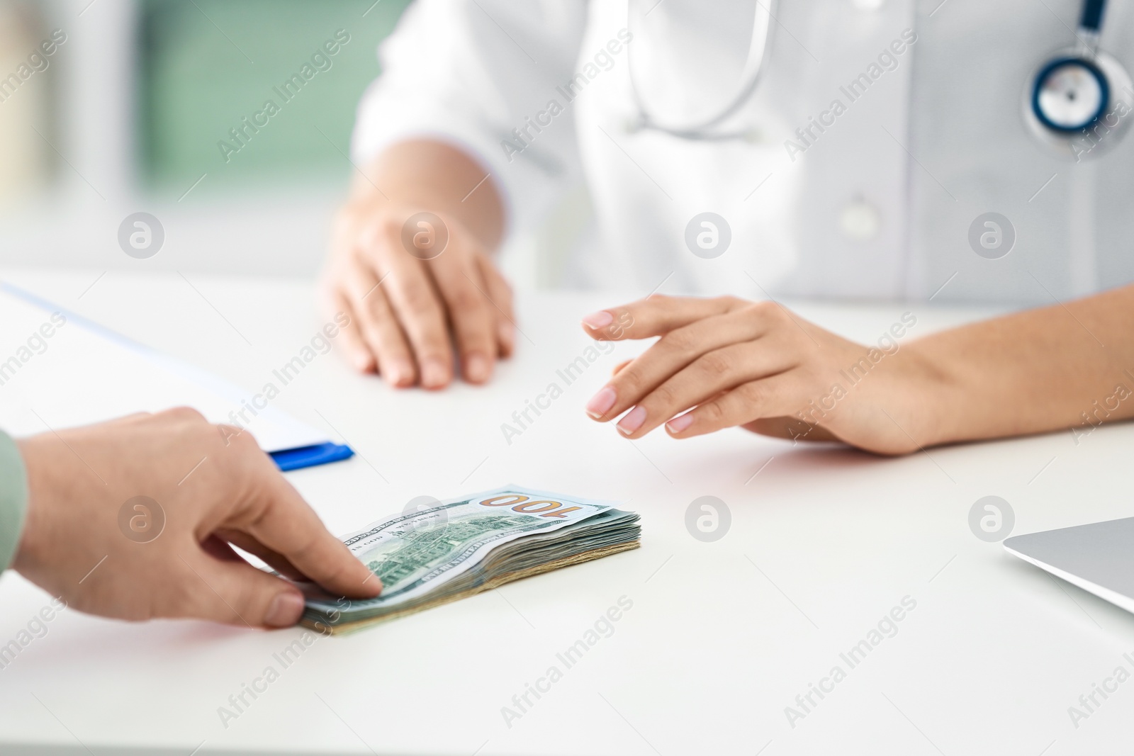 Photo of Patient giving bribe to doctor in clinic, closeup. Corrupted medicine