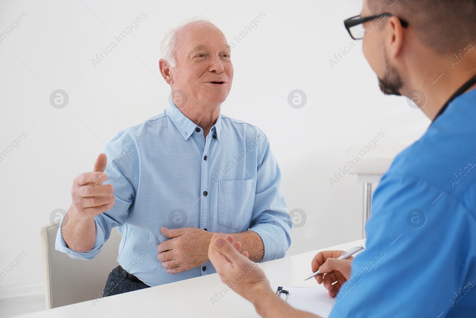 Photo of Doctor examining senior patient in modern office