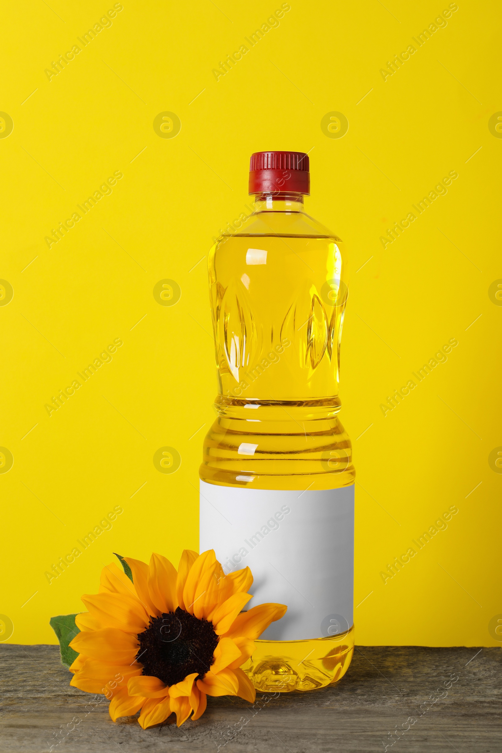 Photo of Bottle of cooking oil, sunflower and seeds on wooden table