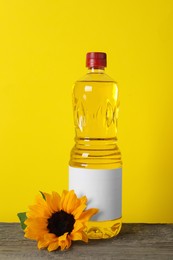 Bottle of cooking oil, sunflower and seeds on wooden table