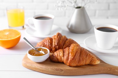 Photo of Croissants and jam on white wooden table. Tasty breakfast