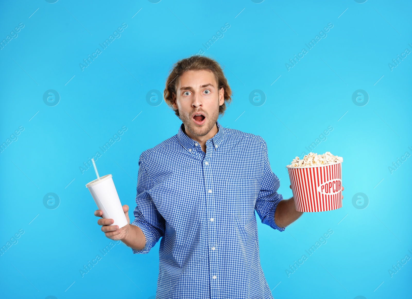 Photo of Emotional man with popcorn and beverage during cinema show on color background