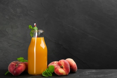 Photo of Natural freshly made peach juice on grey table. Space for text