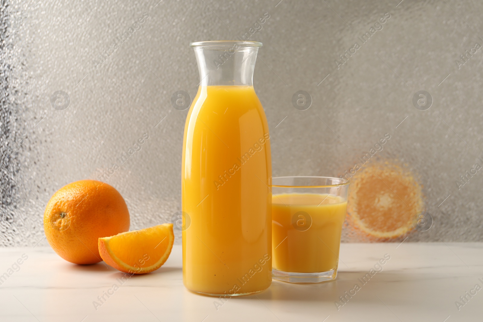 Photo of Tasty fresh oranges and juice on white marble table