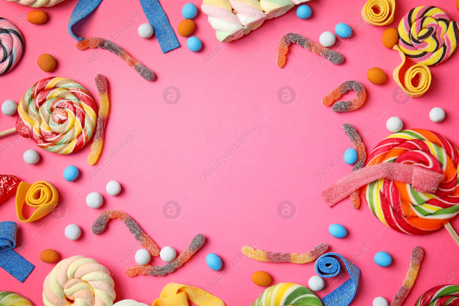 Photo of Flat lay composition with different yummy candies and space for text on color background