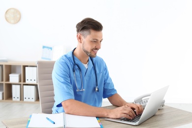 Photo of Male medical assistant at workplace in clinic. Health care service