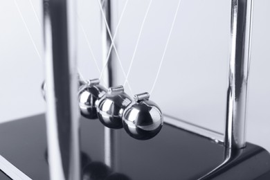 Newton's cradle on light background, closeup. Physics law of energy conservation