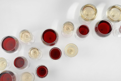 Glass of red and white wines on light background, top view