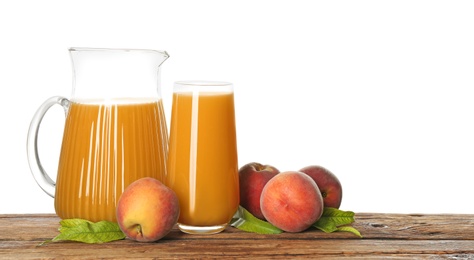 Natural freshly made peach juice on wooden table, white background