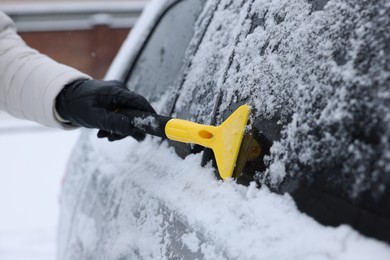 Man cleaning snow from car outdoors, closeup