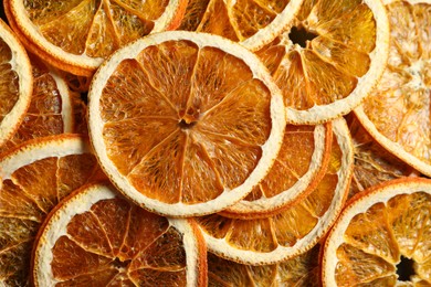 Photo of Heap of dry orange slices as background, top view