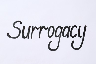 Photo of Word Surrogacy written on white background, top view
