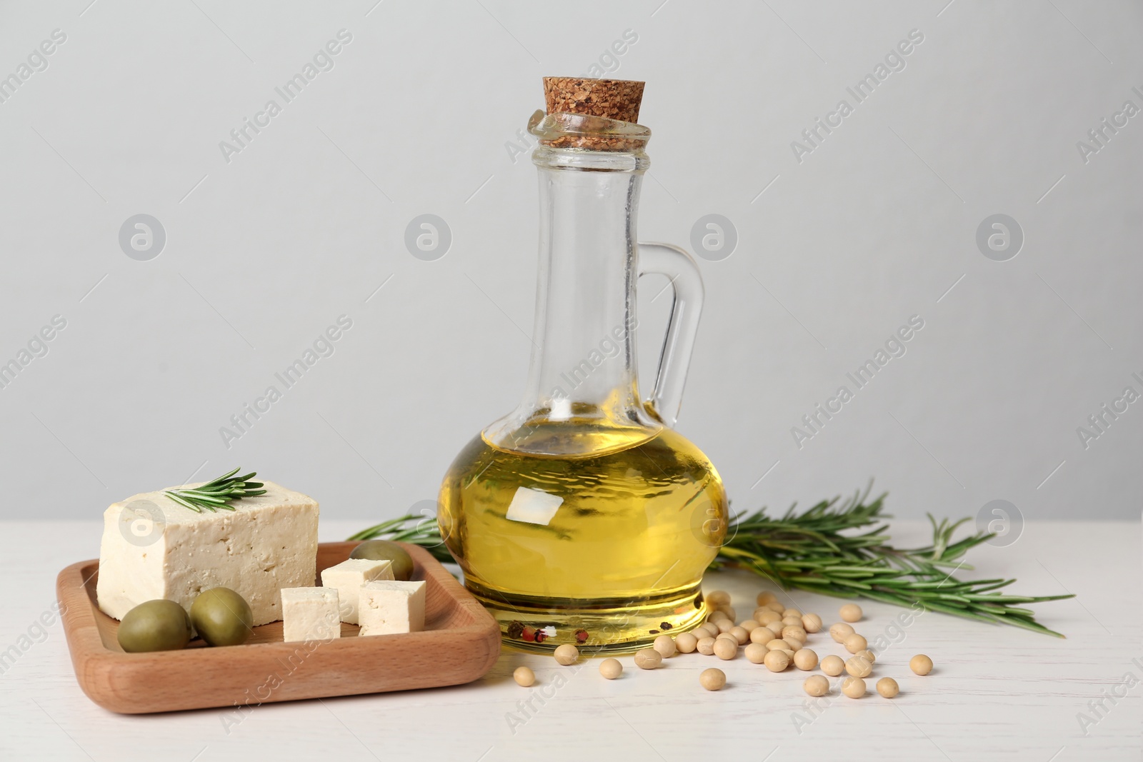 Photo of Pieces of delicious tofu with rosemary, olives and soy on white table