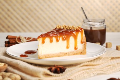 Photo of Tasty cheesecake with caramel and nuts served on table