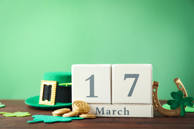 Composition with block calendar on wooden table, space for text. St. Patrick's Day celebration