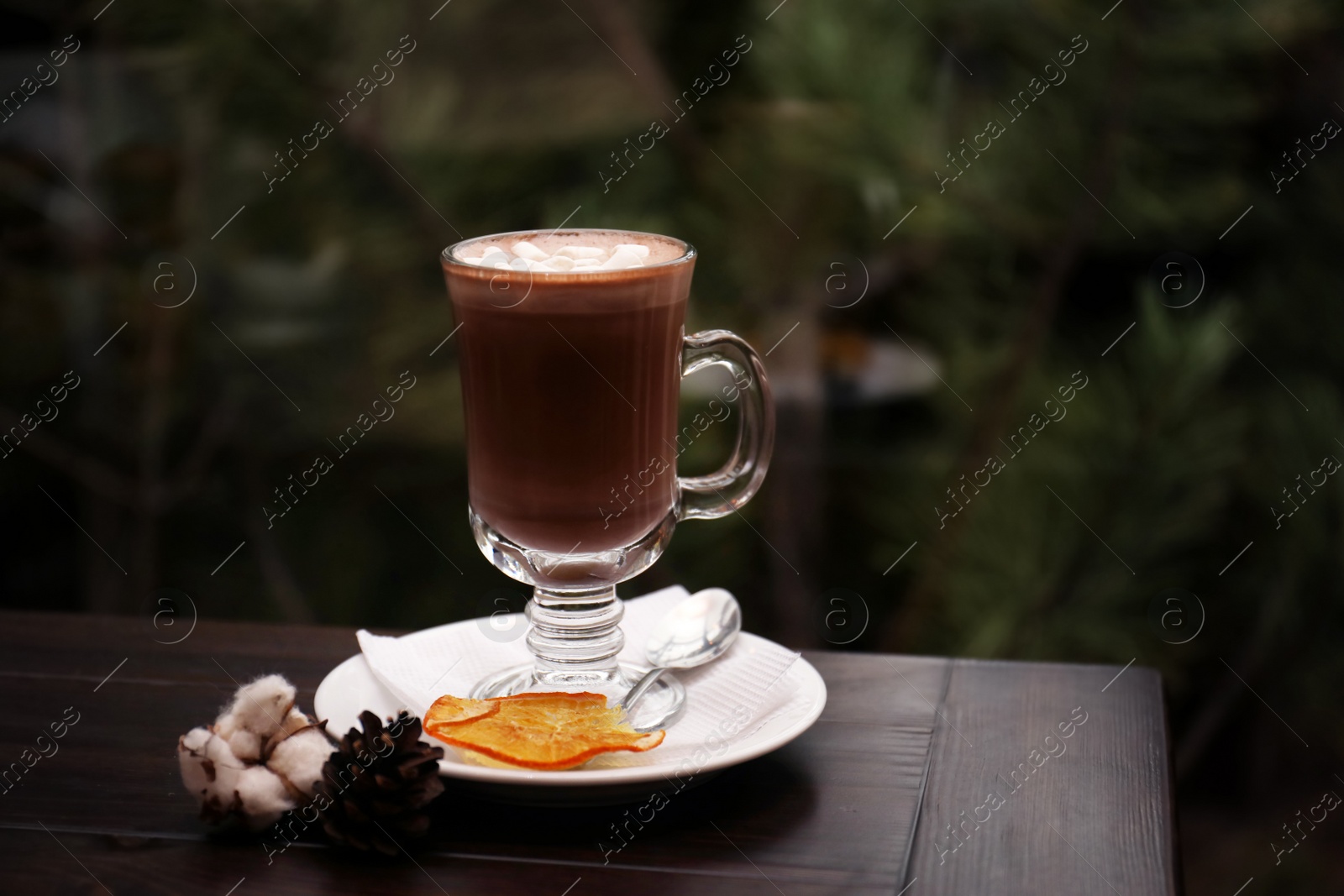 Photo of Cup of aromatic cacao on table against blurred background