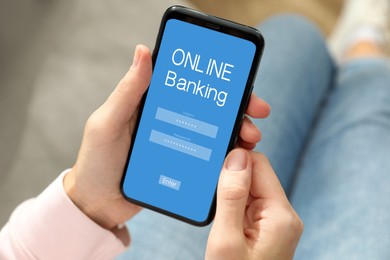 Woman using online banking application on smartphone indoors, closeup