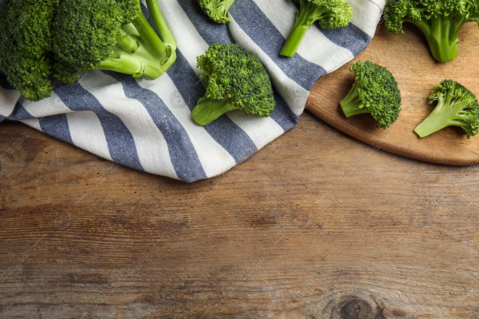 Photo of Fresh green broccoli on wooden table, flat lay. Space for text