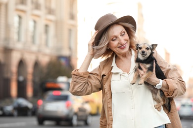 Photo of Beautiful mature woman with cute dog on city street