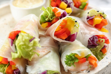 Photo of Delicious rolls wrapped in rice paper on table, closeup