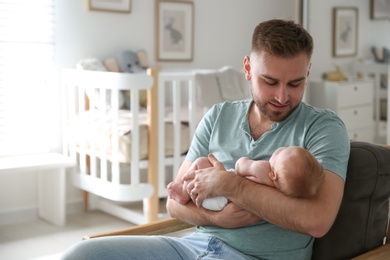 Photo of Father with his newborn son at home