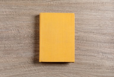 Hardcover book on wooden table, top view