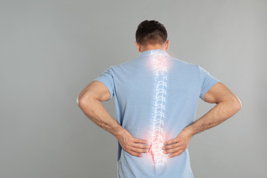Image of Man suffering from pain in spine on grey background
