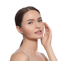 Young woman applying cream under eye on white background