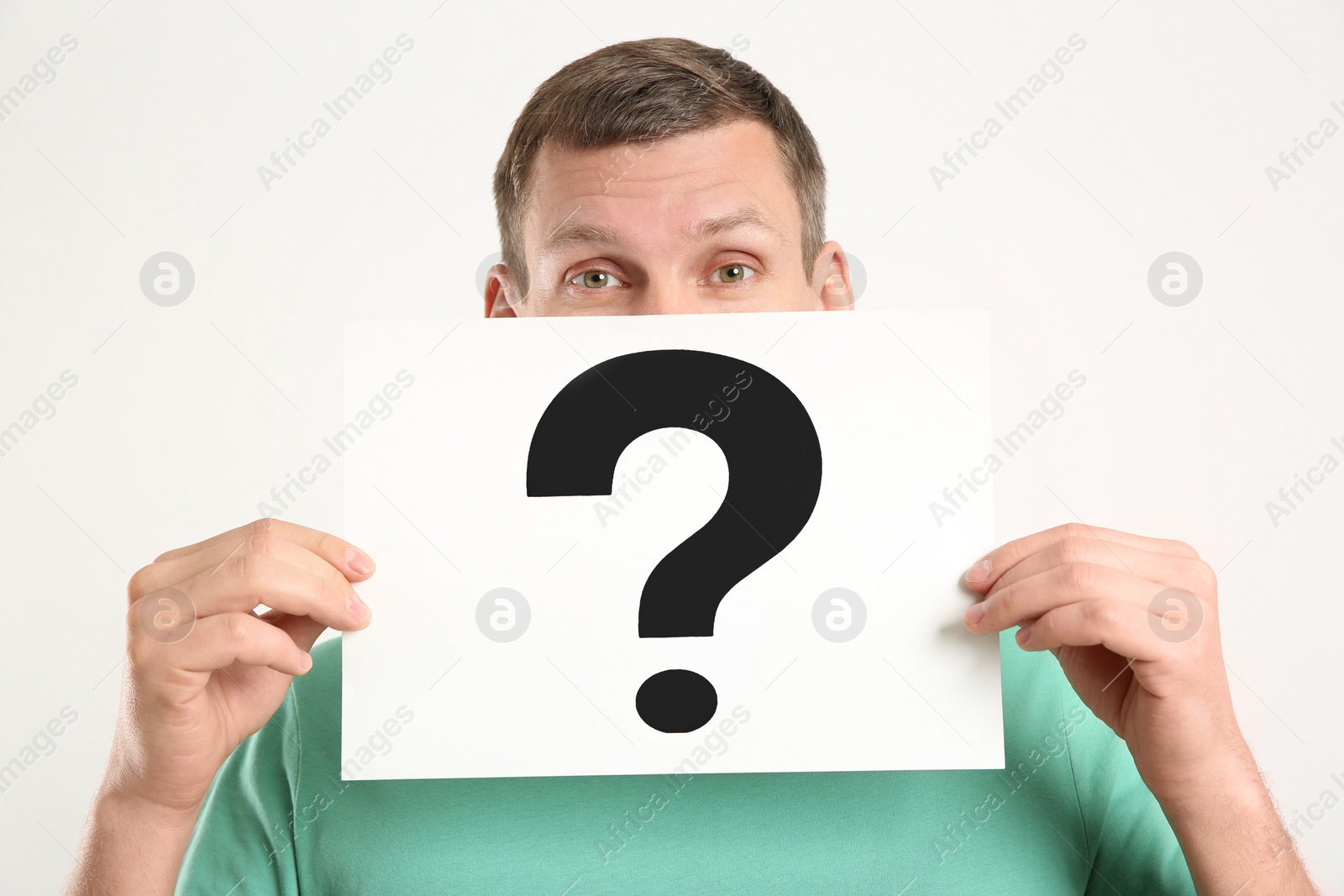 Photo of Man holding paper with question mark on white background